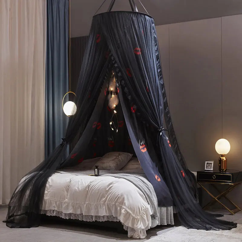 Un lit douillet avec un élégant baldaquin noir décoré de lumières et d'étoiles, créant une ambiance chaleureuse et invitante.