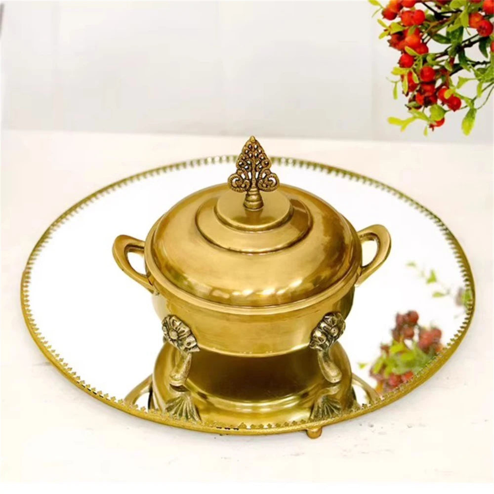 Une magnifique urne dorée ornée de détails délicats, posée sur un plateau rehaussé de filets délicats, formant un ensemble élégant et raffiné.