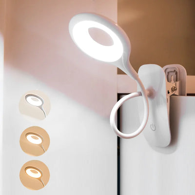 Lampe de chevet à pince blanche sur table de nuit
