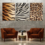 Des toiles décoratives avec des motifs de peau d'animaux comme le tigre, la zèbre et le léopard, complétées par deux fauteuils en velours marron dans une ambiance moderne et chaleureuse.