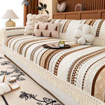 Un lit confortable avec une couverture et des oreillers ornés de motifs ethniques chauds et accueillants, créant une ambiance chaleureuse et cocooning dans la chambre.