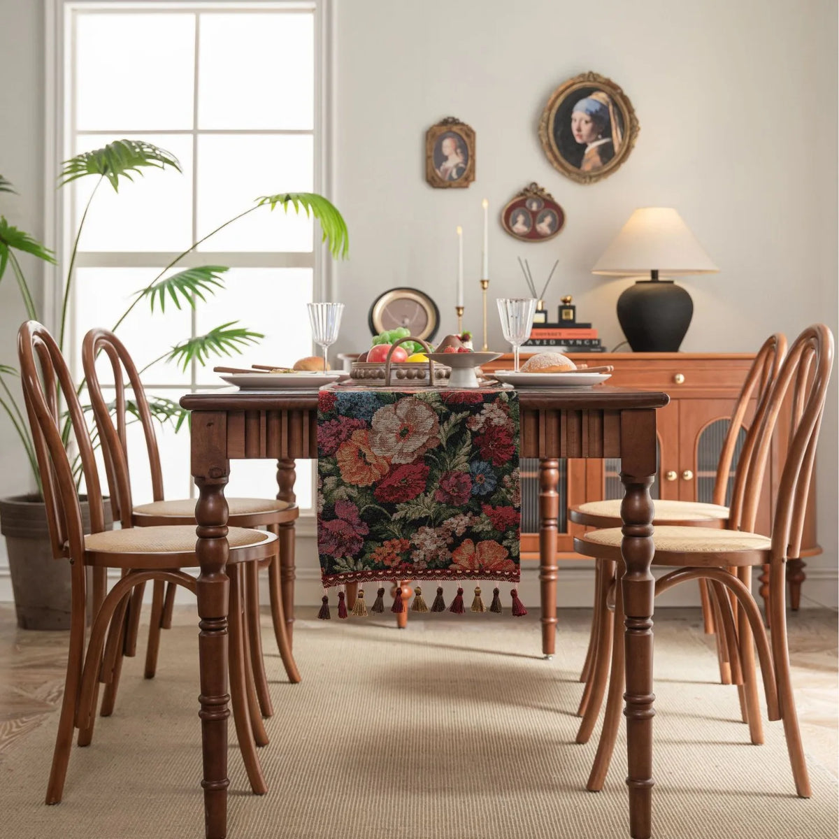 Une salle à manger accueillante avec une table en bois, des chaises en bois sculptées et des décorations vintage sur le mur.