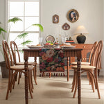 Une salle à manger accueillante avec une table en bois, des chaises en bois sculptées et des décorations vintage sur le mur.