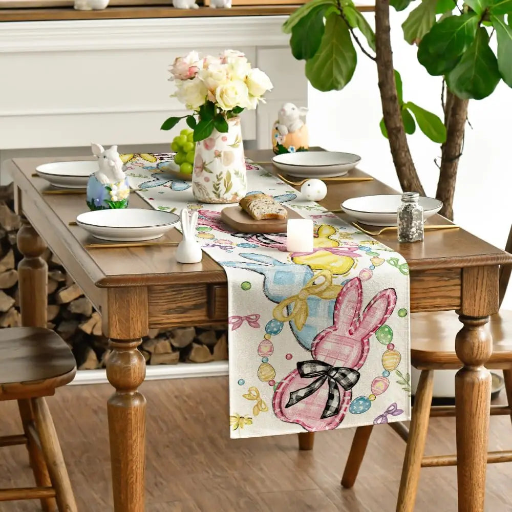 Table décorée avec un chemin de table fleuri et des ornements de Pâques.