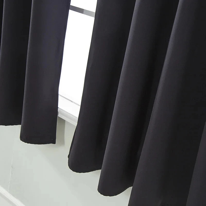 Rideau noir occultant installé sur une fenêtre de chambre