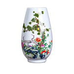 Un vase en porcelaine orné de grues élégantes, de fleurs colorées et de motifs de bambou, créant une image élégante et harmonieuse.
