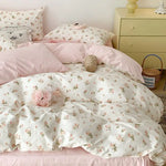 Parure de lit fleurie avec taies d'oreiller et drap plat disposee