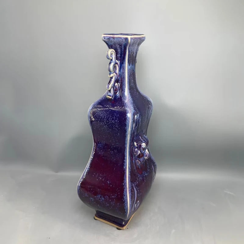 Vase en céramique de forme angulaire et brillante, à la couleur violacée profonde.
