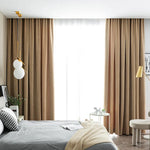 Chambre moderne avec rideaux opaques beige, éclairage suspendu élégant et décoration harmonieuse. Intérieur chaleureux idéal pour améliorer l'ambiance d'une pièce.