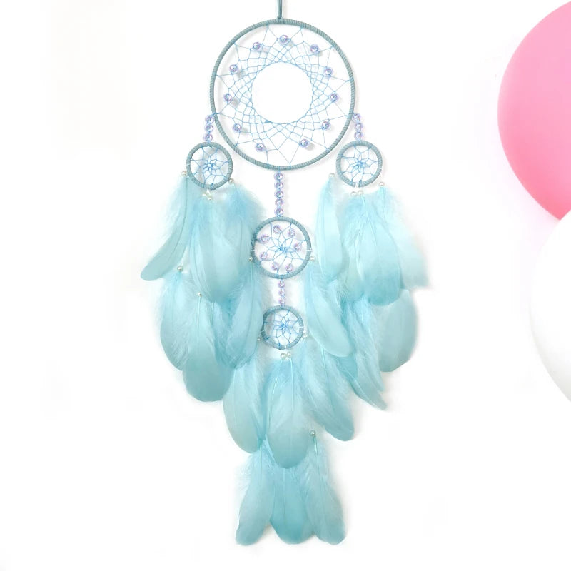 Un capteur de rêves circulaire bleu pâle et blanc décoré de plumes et de perles.