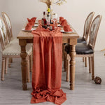serviette table carrée orange franges moderne élégante fourchettes cuillères assiettesbranches séchées guirlande bougie parfumée