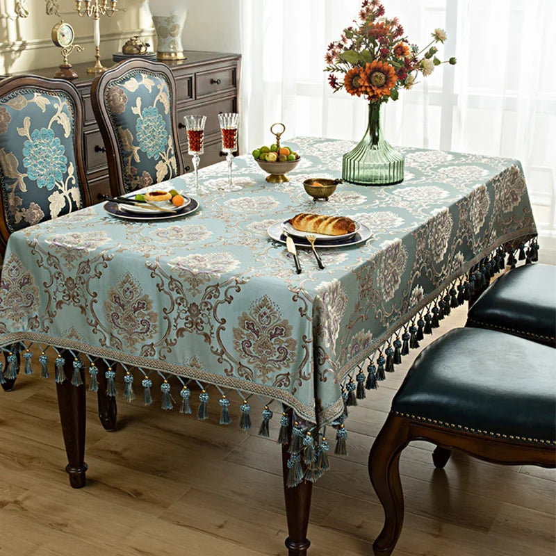 Une table dressée avec un service de vaisselle, des fleurs dans un vase élégant et un décor vintage aux motifs floraux.