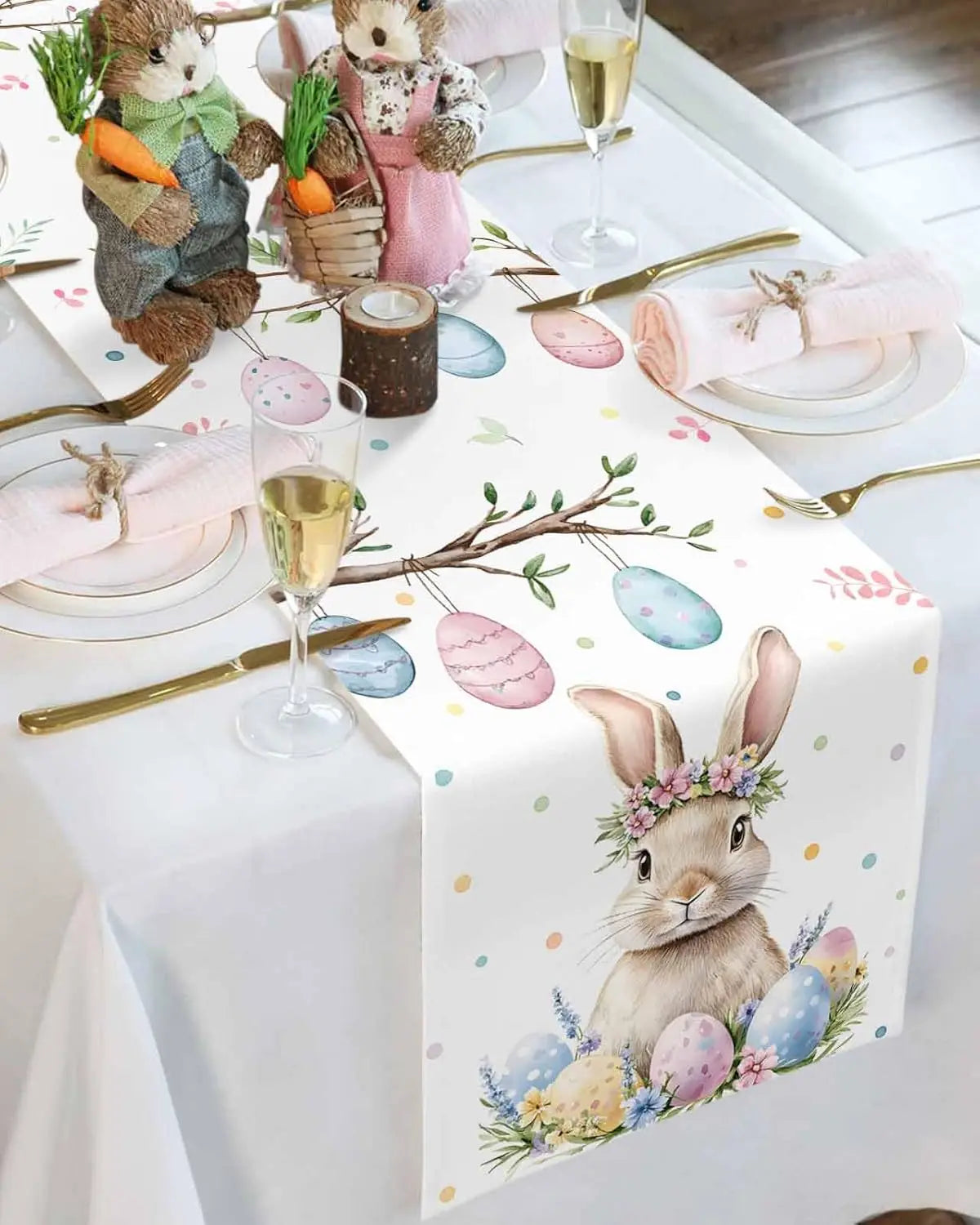 La table de Pâques est décorée avec des figurines de lapins, des oeufs peints, des branches fleuries et des flûtes de champagne, offrant une ambiance festive et printanière.