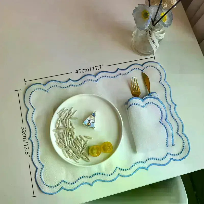serviettes table classiques blanc bleu bordure pointillée douces fourchettes dorées assiettes fromage fleurs artificielles