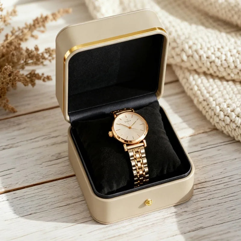 boîte rangement montre cuir beige cadre doré coussin noir organisation bijoux présentation montre dorée