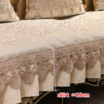 Parure de lit en dentelle brodée, avec une jupe de lit aux délicats motifs de fleurs et de fanions.