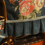 Une robe florale noire et rouge ornée d'une bordure argentée, évoquant l'élégance et le raffinement.