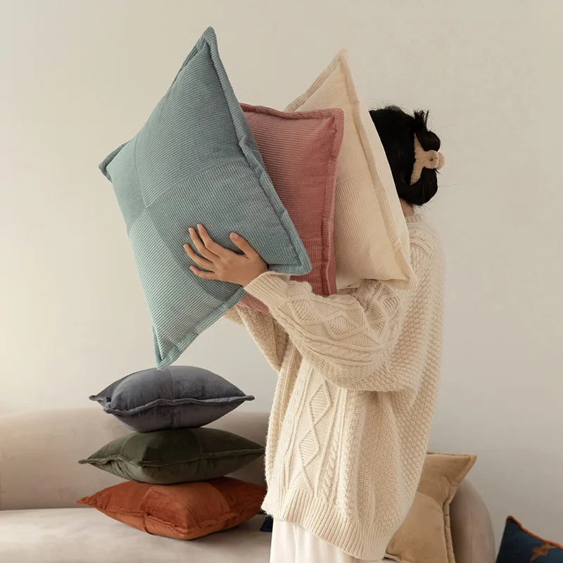 Une pile de coussins confortables aux couleurs douces, créant une ambiance cocooning et chaleureuse.