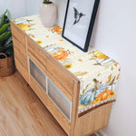 Cette image montre un meuble en bois avec des éléments décoratifs automnaux, notamment des citrouilles, des tournesols et des motifs floraux dans des tons chauds.