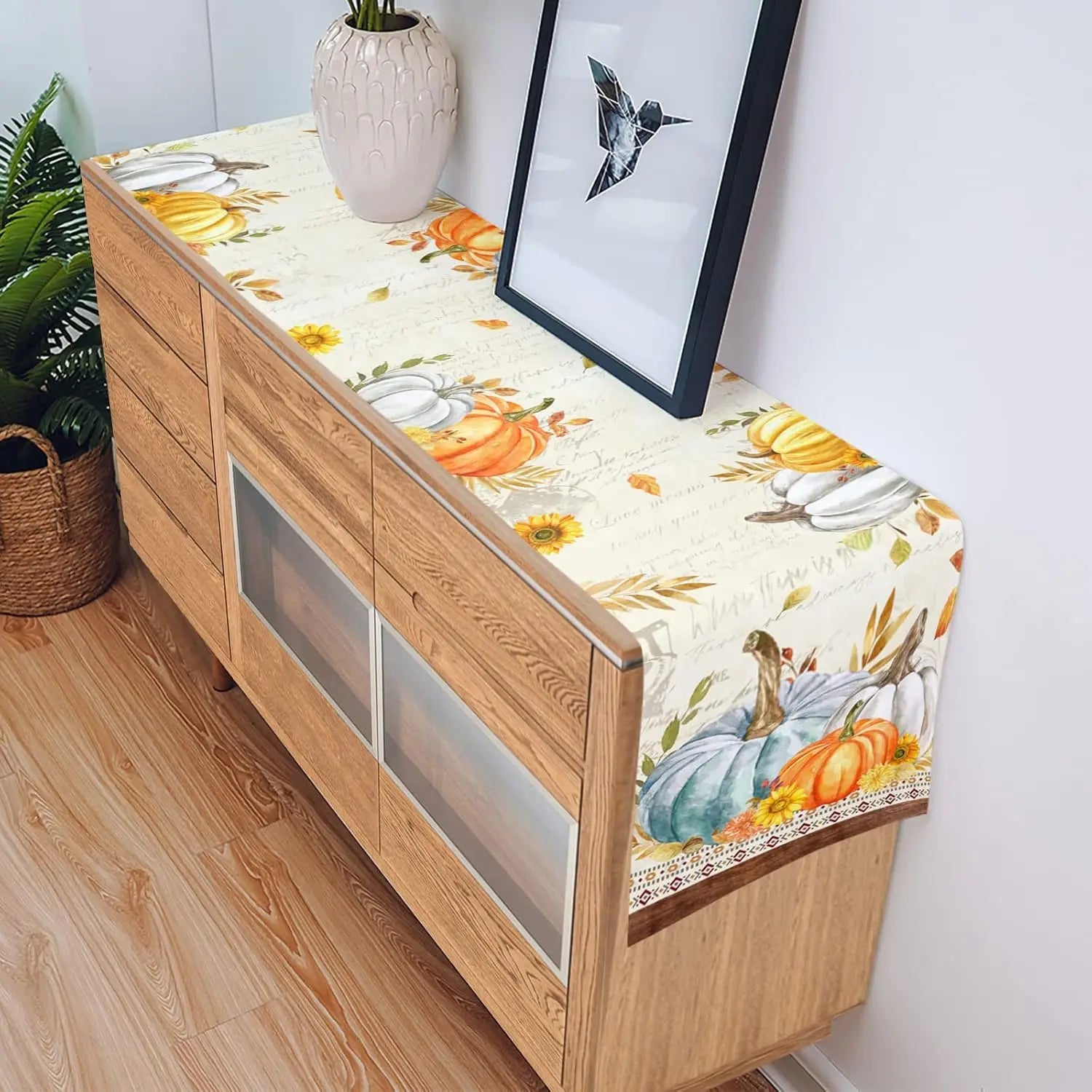 Cette image montre un meuble en bois avec des éléments décoratifs automnaux, notamment des citrouilles, des tournesols et des motifs floraux dans des tons chauds.