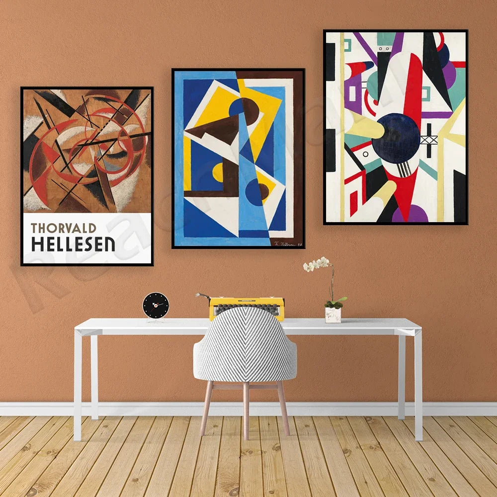 Cette image présente trois tableaux abstraits aux couleurs vives ainsi qu'un espace de travail moderne avec un bureau et une chaise. Le style des oeuvres évoque l'art moderniste du début du XXe siècle.