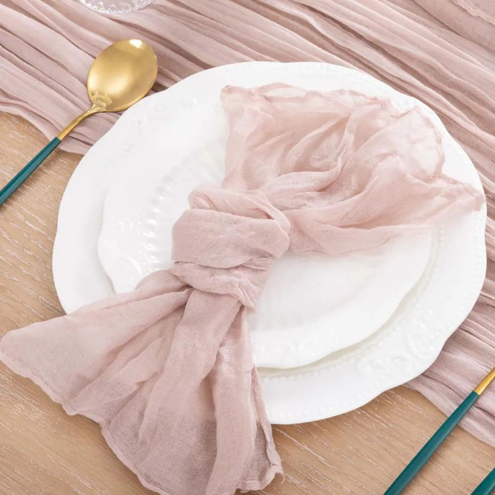Une assiette blanche avec un linge rose décoratif posé délicatement sur une surface en bois.