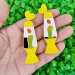Boucles d'oreilles lampe lave violette portées par une femme