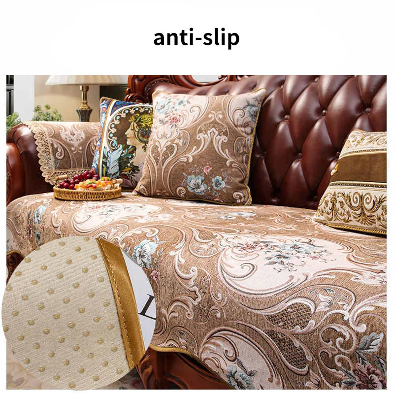 Coussin décoratif avec motifs floraux et paisley sur un canapé en cuir.