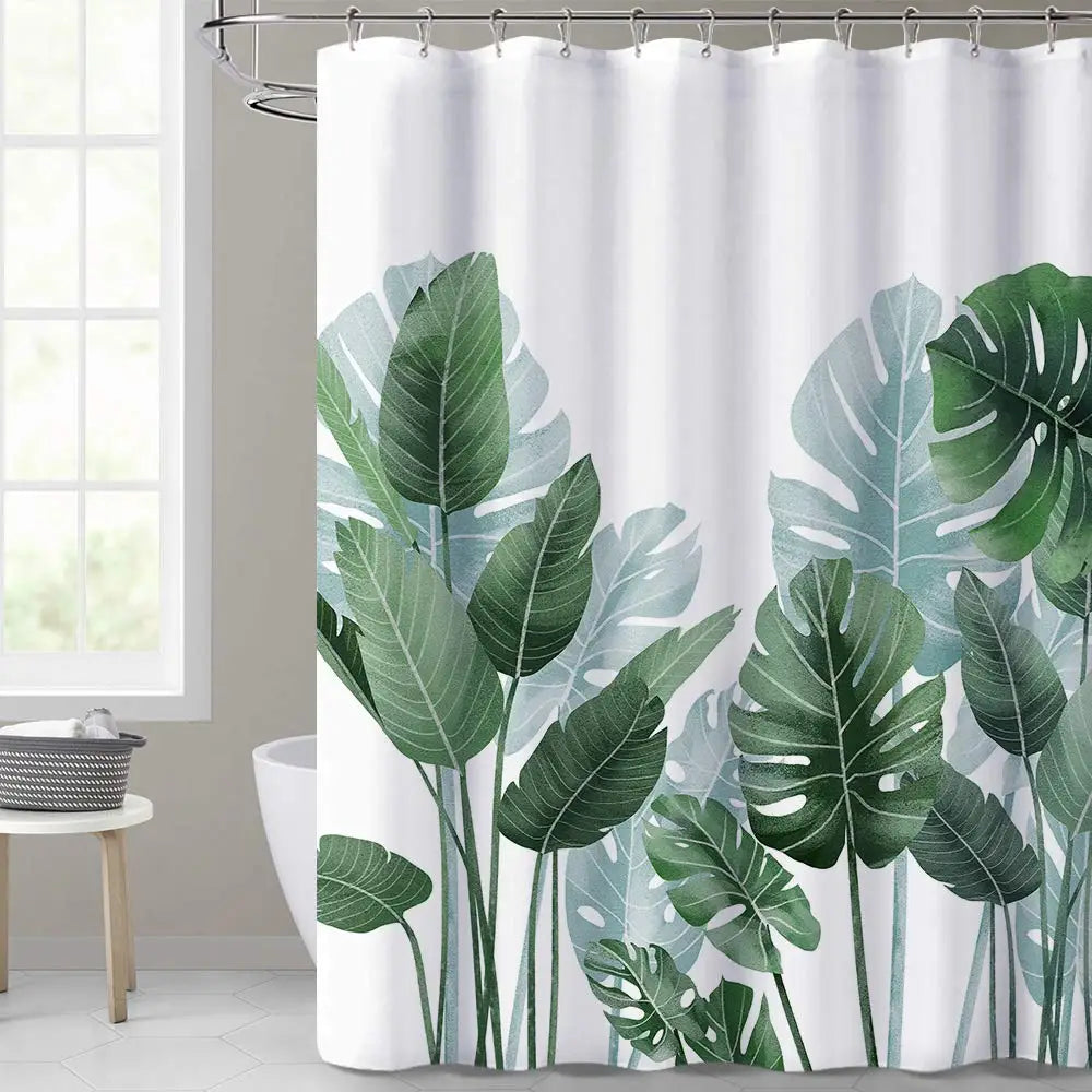 Rideau de douche blanc orné de grandes feuilles de style tropical dans différentes nuances de vert, évoquant des feuilles de monstera et de bananier. 