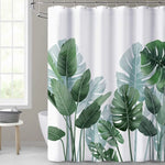 Rideau de douche blanc orné de grandes feuilles de style tropical dans différentes nuances de vert, évoquant des feuilles de monstera et de bananier. 