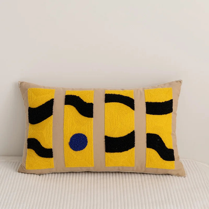 Un coussin décoratif aux motifs géométriques jaunes et noirs, créant une atmosphère moderne et épurée.
