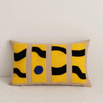 Un coussin décoratif aux motifs géométriques jaunes et noirs, créant une atmosphère moderne et épurée.