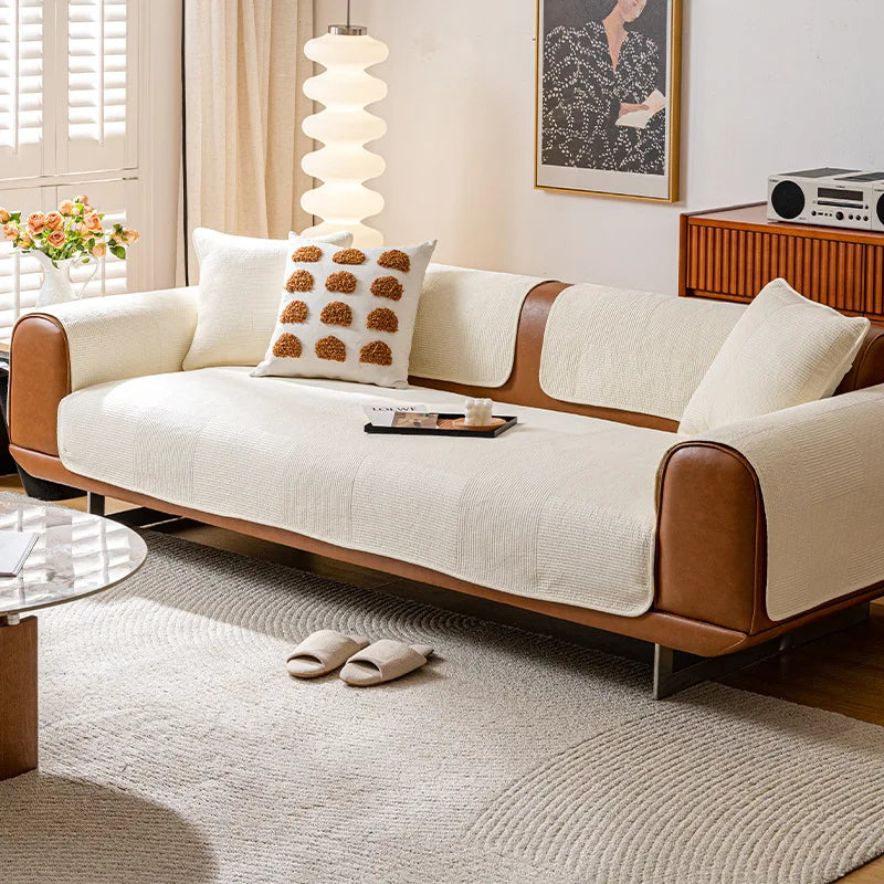 Un canapé confortable en tissu beige avec des accents en bois, dans un salon lumineux avec un tableau décoratif et des accessoires harmonieux.