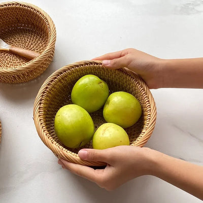 Panier rond en rotin noir pour pain et fruits sur une table de cuisine