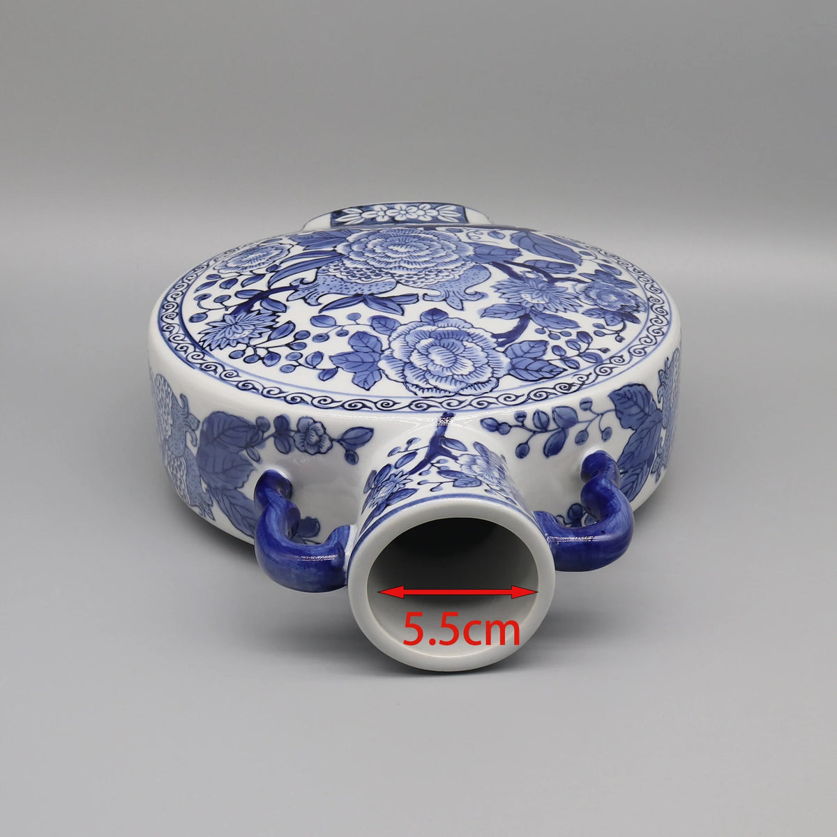 Un pot en céramique de forme ronde avec un motif floral bleu et blanc élaboré, avec une dimension de 5,5 cm.