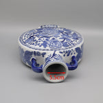 Un pot en céramique de forme ronde avec un motif floral bleu et blanc élaboré, avec une dimension de 5,5 cm.