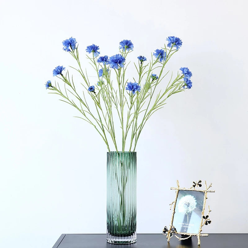 décoration intérieure bouquet fleurs artificielles bleues blanches roses longues tiges vertes vase transparent festonnée