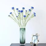 décoration intérieure bouquet fleurs artificielles bleues blanches roses longues tiges vertes vase transparent festonnée