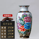 Un grand vase en porcelaine peint avec de magnifiques fleurs colorées telles que des pivoines et des chrysanthèmes.