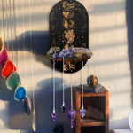 étagère murale noire dorée ornementations astrologiques pendeloques semi précieuses artisanal