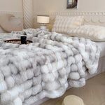 Une couverture en fourrure gris clair qui ajoute une touche de luxe et de confort à cette chambre chaleureuse et élégante.