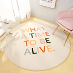 Ce tapis décoratif rond avec l'inscription colorée "What a time to be alive" crée une atmosphère apaisante et inspirante dans cette pièce.