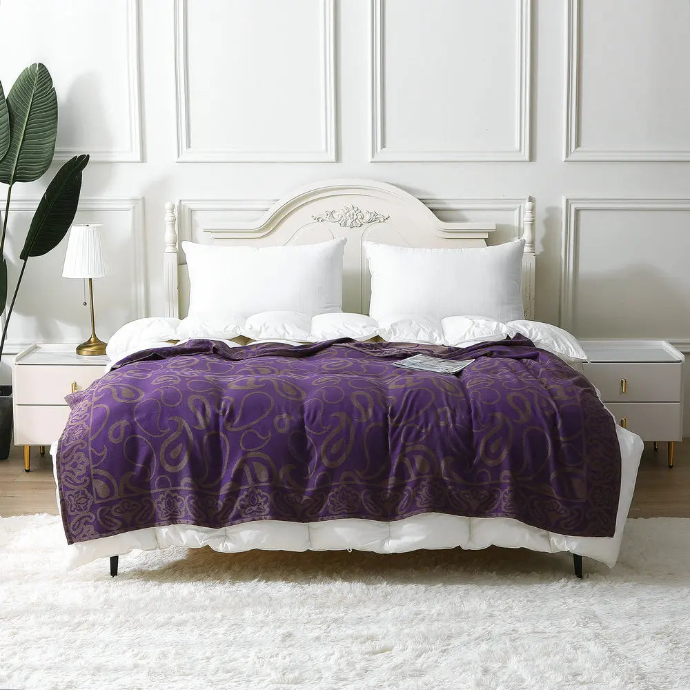 Cette chambre à coucher arbore une atmosphère sophistiquée et élégante avec son lit blanc élégamment décoré d'une couverture violette aux motifs subtils.