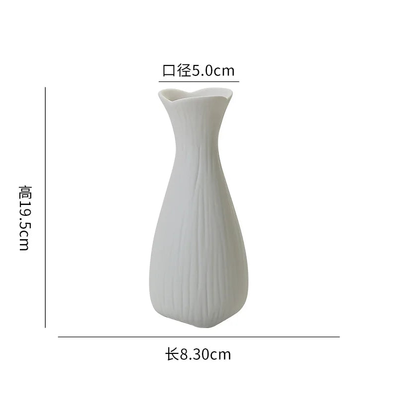 Vase en céramique blanc élégant et épuré avec une forme distinctive.