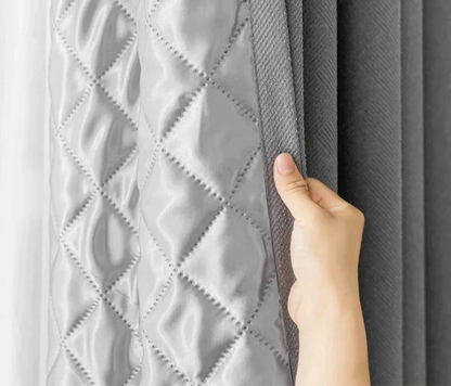 Rideaux isolants thermiques gris avec motif capitonné en losange, offrant une touche d'élégance moderne pour la décoration intérieure. Idéal pour réduire le bruit et améliorer l'efficacité énergétique des pièces. Parfait pour les salons, chambres et bureaux.