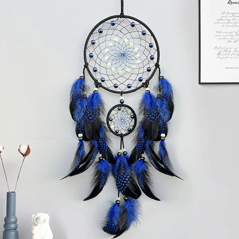 Un magnifique capteur de rêves décoratif avec des plumes bleues et noires, créant un style attrayant et mystique.