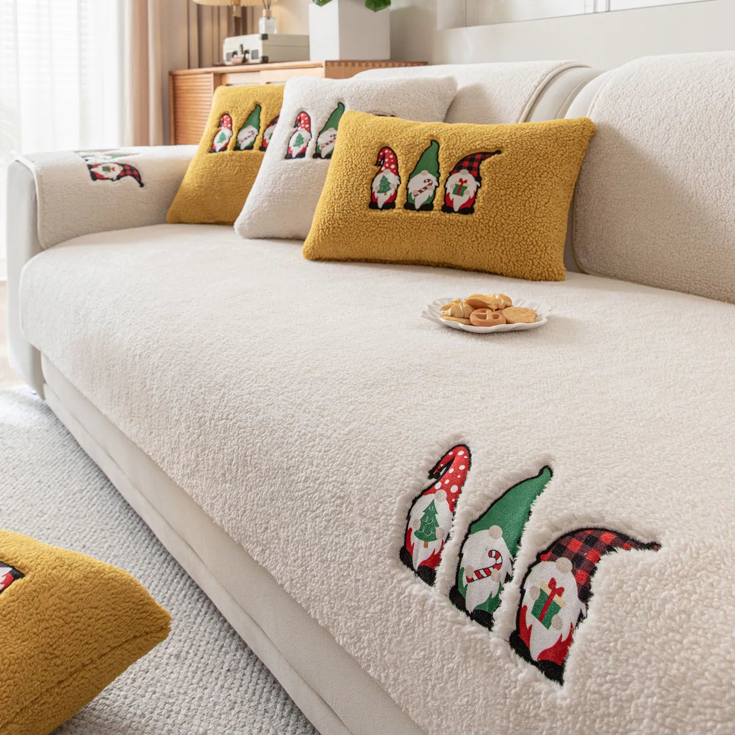 Le salon est décoré avec des coussins moelleux ornés de motifs de lutins de Noël, offrant une atmosphère festive et chaleureuse.