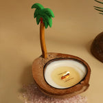 Une bougie parfumée dans un coquillage de noix de coco, avec une décoration tropicale en forme de palmier.