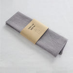 serviettes tissu pliées rustique bohème minimaliste liens anneaux couleurs beige rose vert bleu gris