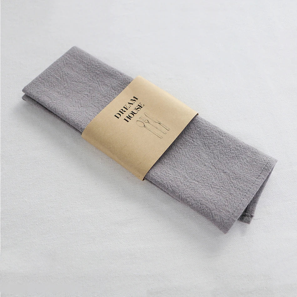 serviettes tissu pliées rustique bohème minimaliste liens anneaux couleurs beige rose vert bleu gris